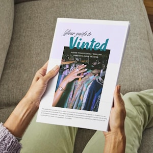Könnte beinhalten: Eine Person hält ein Buch mit dem Titel "Your guide to Vinted". Das Cover zeigt einen türkis-weißen Titel mit einem Bild von Kleiderständern. Der Untertitel des Buches lautet: "Ein Leitfaden für den erfolgreichen Weiterverkauf von Artikeln mit Gewinn auf Vinted."