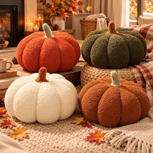 Può includere: Quattro cuscini in peluche a forma di zucca nei colori arancione, verde scuro, crema e ruggine. Ogni cuscino presenta un tessuto testurizzato simile allo sherpa, profonde scanalature verticali e un piccolo stelo a contrasto sulla sommità.