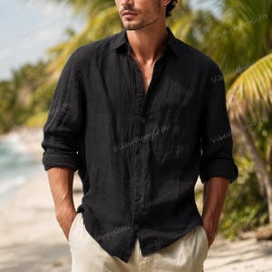 Può includere: Camicia nera a maniche lunghe con bottoni e colletto classico. La camicia è realizzata in un tessuto leggero e strutturato. Le maniche sono arrotolate. La camicia è abbinata a pantaloni chiari. Lo sfondo mostra una scena di spiaggia con palme.