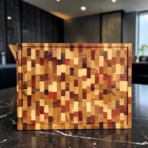 May include: A rectangular end-grain chopping board featuring a mosaic pattern of various wood tones including light cream, golden tan, deep red, and dark brown. The board has a recessed juice groove running along the perimeter of the surface.