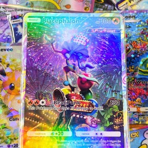 May include: A holographic Blacephalon Pokémon card with a colorful design. The card features a cartoon character with a polka-dot hat and a fireworks background. The text "Beat Punk" and "Ultra Beast" are visible.