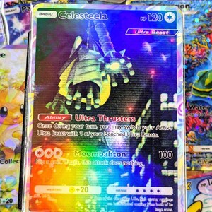 May include: A holographic Pokémon trading card featuring Celesteela, an Ultra Beast. The card has a rainbow foil background with text including "Celesteela", "Ultra Beast", and "Moombahton". The card's HP is 120.