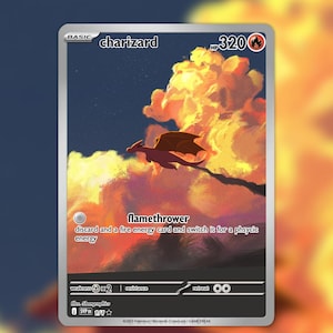 Könnte beinhalten: Eine Charizard-Sammelkarte mit der Silhouette eines Drachen, der vor orangefarbenen und gelben Wolken bei Sonnenuntergang fliegt. Die Karte zeigt 320 KP, die Attacke Flammenwurf und englischen Text zu den Energiekostenregeln.