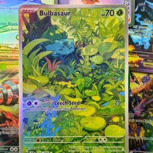 Könnte beinhalten: Holografische Bulbasaur Pokémon-Karte in Grün und Blau. Die Karte zeigt die Figur in einer grünen Umgebung mit den Texten "Bulbasaur" und "Leech Seed". Teil der 166/165-Serie, ein Sammelkartenspiel.