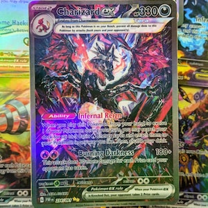 Può includere: Una carta Pokémon Charizard EX olografica. La carta presenta un'illustrazione dettagliata di una creatura simile a un drago con ali rosse e nere. Il testo include "Charizard EX", "Infernal Reign" e "Burning Darkness".