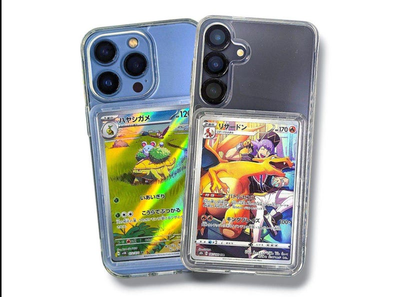 May include: Two clear phone cases, one blue and one black, each holding a Pok&eacute;mon trading card. The blue case has a card with a turtle-like creature. The black case has a card with a Charizard illustration.