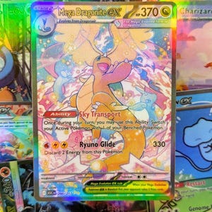 May include: A holographic Mega Dragonite EX Pokémon card. The card features a large orange and pink dragon with a colorful background. The card text includes "Sky Transport" and "Ryuno Glide".