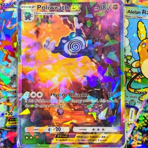 Può includere: Una carta Pokémon olografica con Poliwrath EX. La carta presenta un'illustrazione di Poliwrath blu e bianco, con il testo "Hydro Knuckle" e "HP 180". La carta è circondata da altre carte Pokémon.