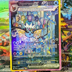 Könnte beinhalten: Eine holografische Vaporeon ex Pokémon-Karte. Die Karte zeigt ein blaues Vaporeon mit einem Buntglasfenster-Design. Die Karte hat den Text "Severe Squall" und "Aquamarine". Die Karte stammt aus der Pokémon ex-Serie.
