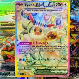 Może przedstawiać: Holograficzna karta kolekcjonerska Pokémon Eevee EX. Karta przedstawia kolorową ilustrację Eevee z tekstem "Eevee EX", "Rainbow DNA" i "Coruscating Quartz". Karta ma 200 HP i jest częścią zestawu PREEN 167/131.