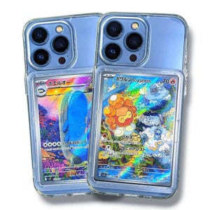 May include: Two clear phone cases with blue backs, each holding a Pok&eacute;mon trading card. One card features a blue whale-like creature, the other an orange and yellow character. The cards have Japanese text and colorful holographic backgrounds.