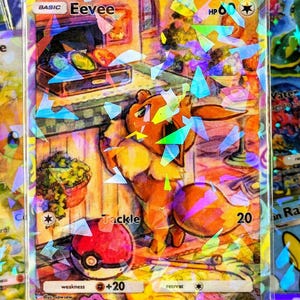 Może przedstawiać: Holograficzna karta kolekcjonerska Pokémon Eevee. Karta przedstawia ilustrację Eevee z Poké Ballem i słowem "Tackle". Karta ma 60 HP i słabość +20. Karta jest otoczona holograficzną folią.