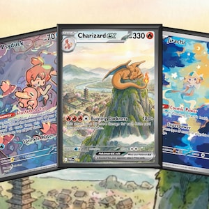 Könnte beinhalten: Drei gerahmte Pokémon-Sammelkarten. Die mittlere Karte zeigt ein Charizard EX mit einem Berglandschaftshintergrund. Die anderen Karten zeigen Psyduck und Jirachi. Die Karten haben verschiedene Farben und Text.