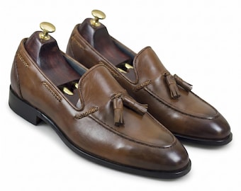 Zapatos de vestir sin cordones para hombre, de cuero marrón, hechos a mano, con borlas y detalles trenzados.