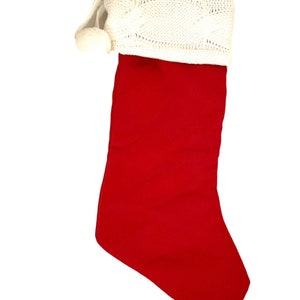 May include: A red Christmas stocking with a white knitted cuff and a white pom-pom.