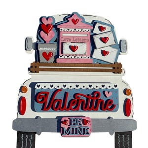 May include: A white pickup truck with a pink mailbox that says "Love Letters" on the back. The truck is decorated with red hearts and the words "Valentine" and "Be Mine".
