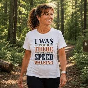 Könnte beinhalten: Ein weißes Kurzarm-T-Shirt mit dem Text I WAS TOLD THERE WOULD BE SPEED WALKING in einer Kombination aus dunkelblauen und orangefarbenen Blockbuchstaben, ergänzt durch dekorative horizontale Linien und Pfeile auf der Vorderseite.