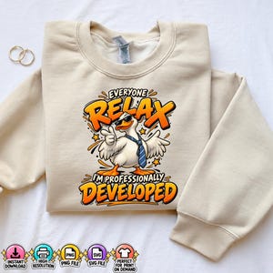 May include: A beige crewneck sweatshirt featuring a graphic of a white duck wearing sunglasses and a blue necktie. The text reads "EVERYONE RELAX I'M PROFESSIONALLY DEVELOPED" in bold orange letters. The design includes small yellow stars and orange accents.