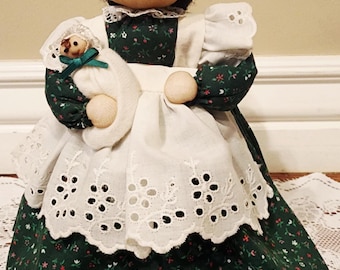 Muñeca de peluche vintage sosteniendo a un bebé