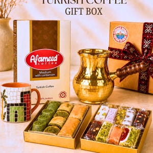 May include: An authentic Turkish coffee gift box set featuring a box of Afameed medium roast coffee with cardamom, a gold-toned hammered metal coffee pot with a wooden handle, a mosaic-patterned mug, and two gold boxes filled with assorted baklava and Turkish delight.
