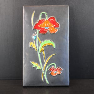 Vintage wandtegel met bloemenmotief.