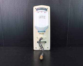 Antieke vintage bloemenkoffiemolen voor aan de muur.