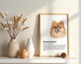 May include: A framed wall art print featuring a portrait of a tan Pomeranian dog with the text "Pomeranian" and a dictionary-style definition below the image. The print is displayed in a light wood frame alongside two ceramic vases and a small pinecone.