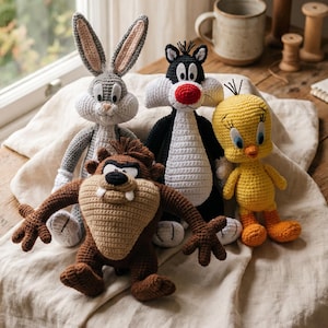 May include: A set of four crocheted stuffed toys featuring cartoon characters: a gray rabbit with long ears, a black and white cat with a red nose, a brown creature with a wide mouth and fangs, and a small yellow bird with orange feet.