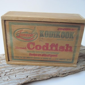 May include: A wooden box with a label that reads "Lasco Kod-Kook Boned Codfish" and "Prepared with Salt Only - No Preservatives - Recipe on side of box". The box is brown with green and red lettering.