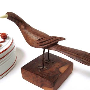 Pájaro de madera tallada vintage sobre soporte