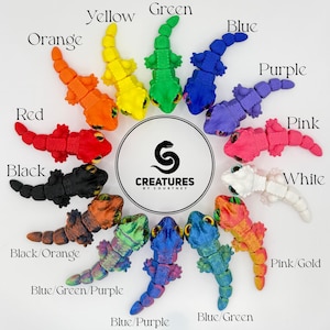 Pode incluir: Uma cole&ccedil;&atilde;o de figuras de lagartos articulados coloridos em v&aacute;rias cores, incluindo vermelho, laranja, amarelo, verde, azul, roxo, rosa, preto e branco. As figuras s&atilde;o dispostas em torno de um logotipo central que diz "Creatures by Courtney."