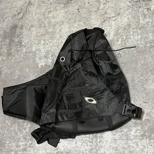 May include: Black sling backpack with a honeycomb pattern and a white logo. The bag features multiple compartments, a mesh pocket, and adjustable straps with a buckle closure. The bag is designed to be worn across the body.