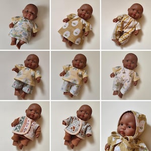 May include: A collection of nine images featuring a dark-skinned baby doll wearing various outfits including floral dresses, patterned rompers, short sets, and a hooded jacket with brown leggings, showcasing diverse fabric prints and styles.
