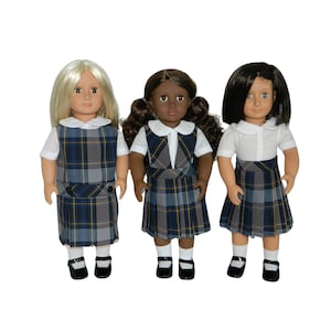 May include: Three dolls wearing school uniforms. Each doll has a different skin tone and hairstyle. The uniforms consist of a white collared shirt, a plaid jumper in shades of blue, gray, and yellow, white socks, and black shoes.