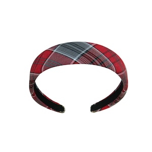 May include: A red, black, and gray plaid headband. The padded headband features a classic tartan pattern. The interior is black. This hair accessory is a stylish addition to any outfit.