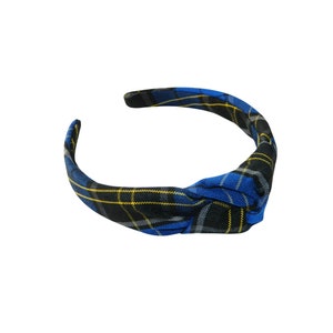 May include: A blue, black, and yellow plaid headband with a knotted design.