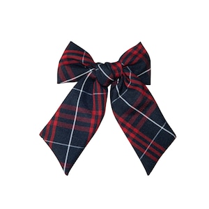 May include: A red and blue plaid bow tie. The bow tie is made of a soft fabric and has a classic design.