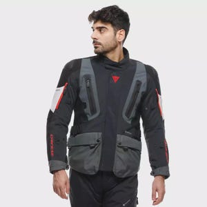 May include: Black and grey motorcycle jacket with red detailing. It has multiple pockets, zips, and the brand name "DAINESE" in red on the sleeve. A red triangle logo is on the chest.