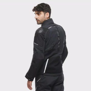 May include: Black motorcycle jacket with reflective detailing and padded shoulders. The jacket has a high collar, multiple panels, and a textured back. The sleeves feature reflective stripes, and the jacket appears to be made of a durable, weather-resistant material.