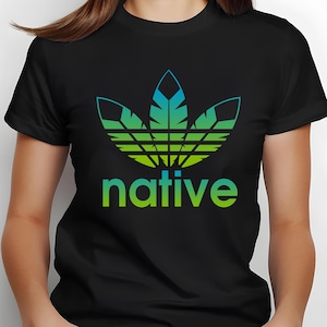 May include: Black t-shirt with a Native American-inspired design. The design features a stylized feather emblem in shades of green and blue, with the word "native" in green below. The text "DESIGN #9" is in the upper left corner.