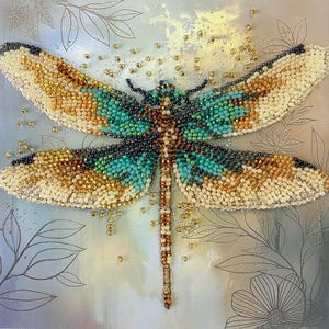 Può includere: Un'opera d'arte a forma di libellula con perline e dettagli intricati. La libellula presenta ali nei toni crema, oro, verde acqua e nero. Il corpo è marrone e verde acqua. Lo sfondo è azzurro con motivi floreali e di foglie.