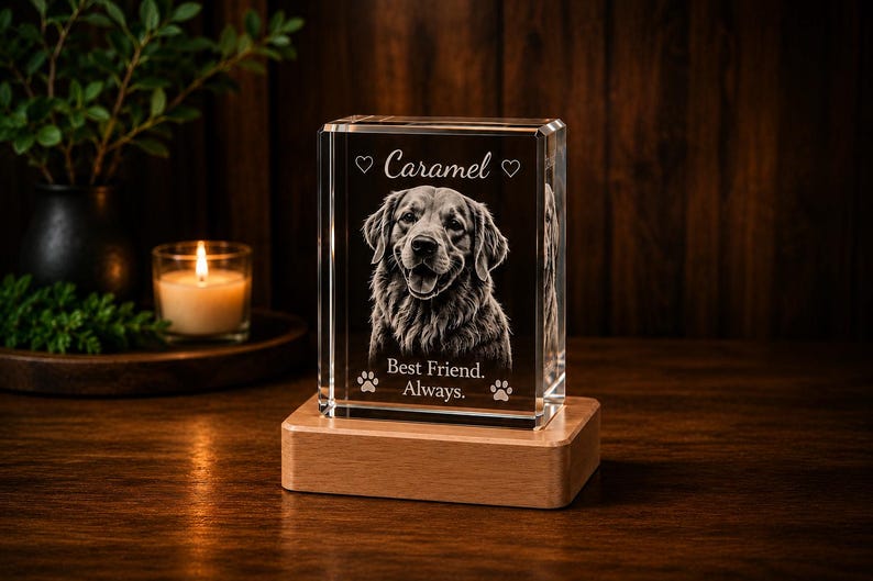 May include: A rectangular clear glass block featuring a laser-etched portrait of a dog. The text "Caramel" is engraved at the top between two hearts, and "Best Friend. Always." is at the bottom with two paw prints. It sits on a wooden base.