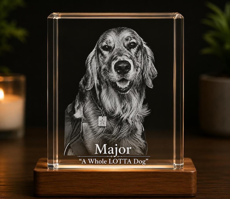 May include: A rectangular clear glass block featuring a laser-etched portrait of a dog wearing a collar with a star-shaped tag. The text Major and A Whole LOTTA Dog are etched below the dog. The glass block rests on a rectangular wooden base.