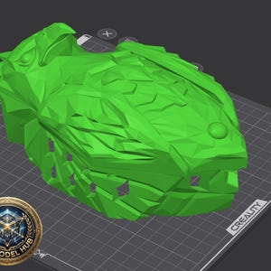 May include: A bright green, 3D-printed model of a fish head, resting on a gray surface with a grid pattern. The model has detailed scales and a prominent eye. A logo for "3D Model Hub" is in the lower left corner.