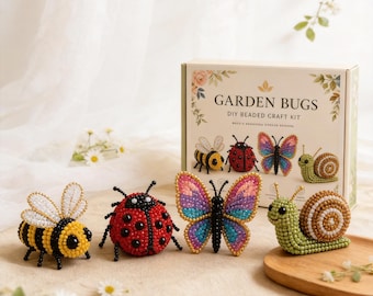 Puede incluir: Un kit de manualidades de abalorios "Garden Bugs" con figuras de insectos de abalorios: una abeja, una mariquita, una mariposa y un caracol. La caja del kit muestra el título e imágenes de los insectos terminados. Los insectos están hechos de cuentas de colores.