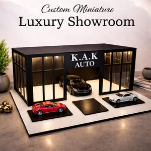 May include: A custom miniature luxury showroom with the text "Custom Miniature Luxury Showroom" and "K.A.K AUTO". The showroom features a black exterior with glass windows and three miniature cars: a red sports car, a black sedan, and a white sports car.