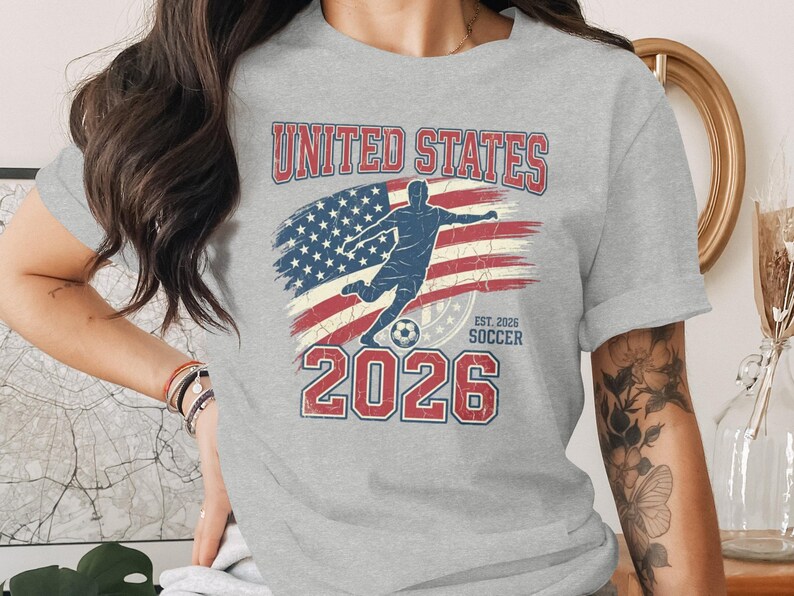 Gray t-shirt with United States Soccer 2026 graphic and American flag.