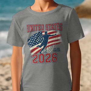 Grey t-shirt with "United States 2026" and soccer player silhouette.