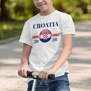 Boy in white t-shirt with Croatia 2026 text and flag design.