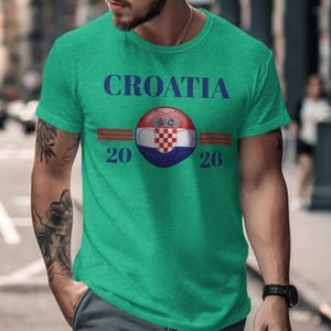 Green t-shirt with Croatia 2026 text and flag logo.